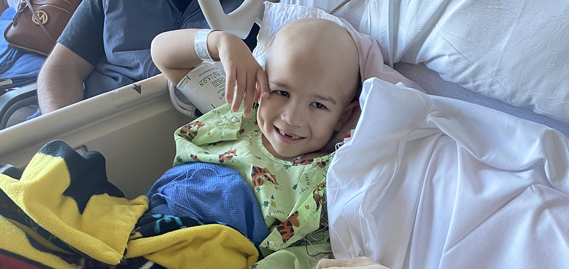 Boy in hospital gown lying on bed